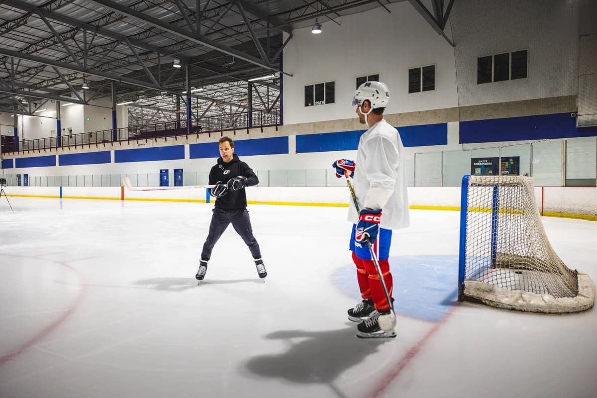Coach Kevin on the ice working with a player